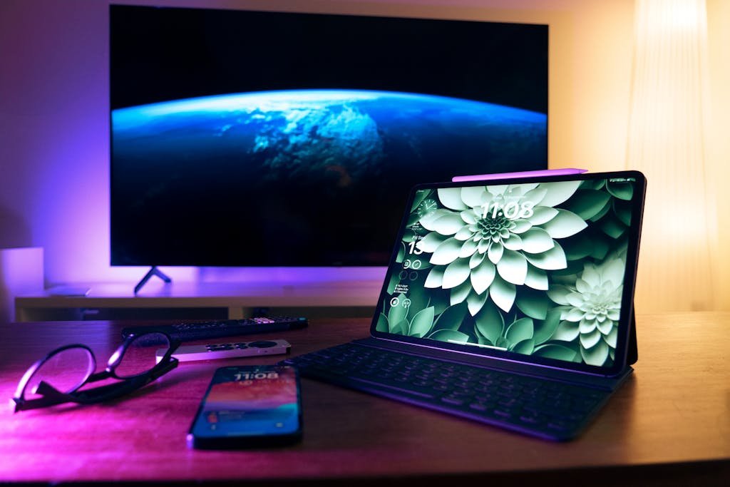 Stylish home office setup featuring devices like tablet, smartphone, and large screen display.