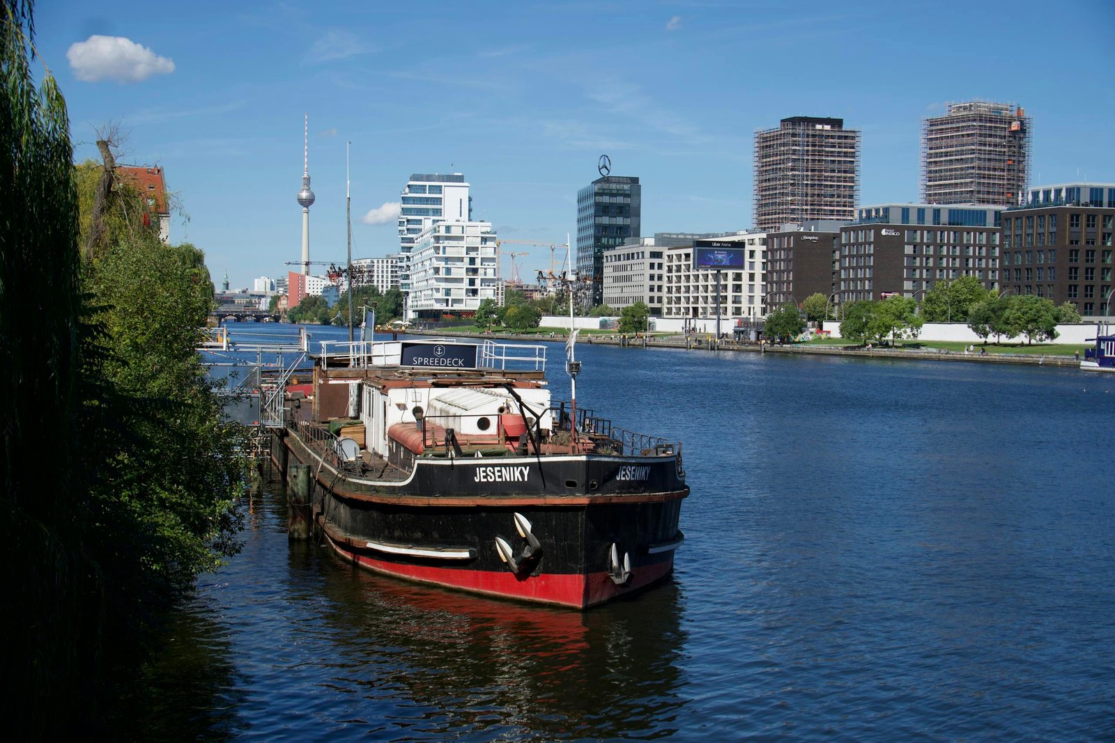 Cargo boat on the Spree River with Berlin TV Tower in background, Berlin, Germany
